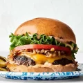 O chifla de burger cu carne, salata, rosie, ceddar