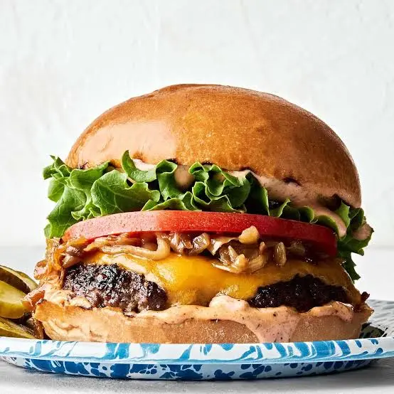 O chifla de burger cu carne, salata, rosie, ceddar